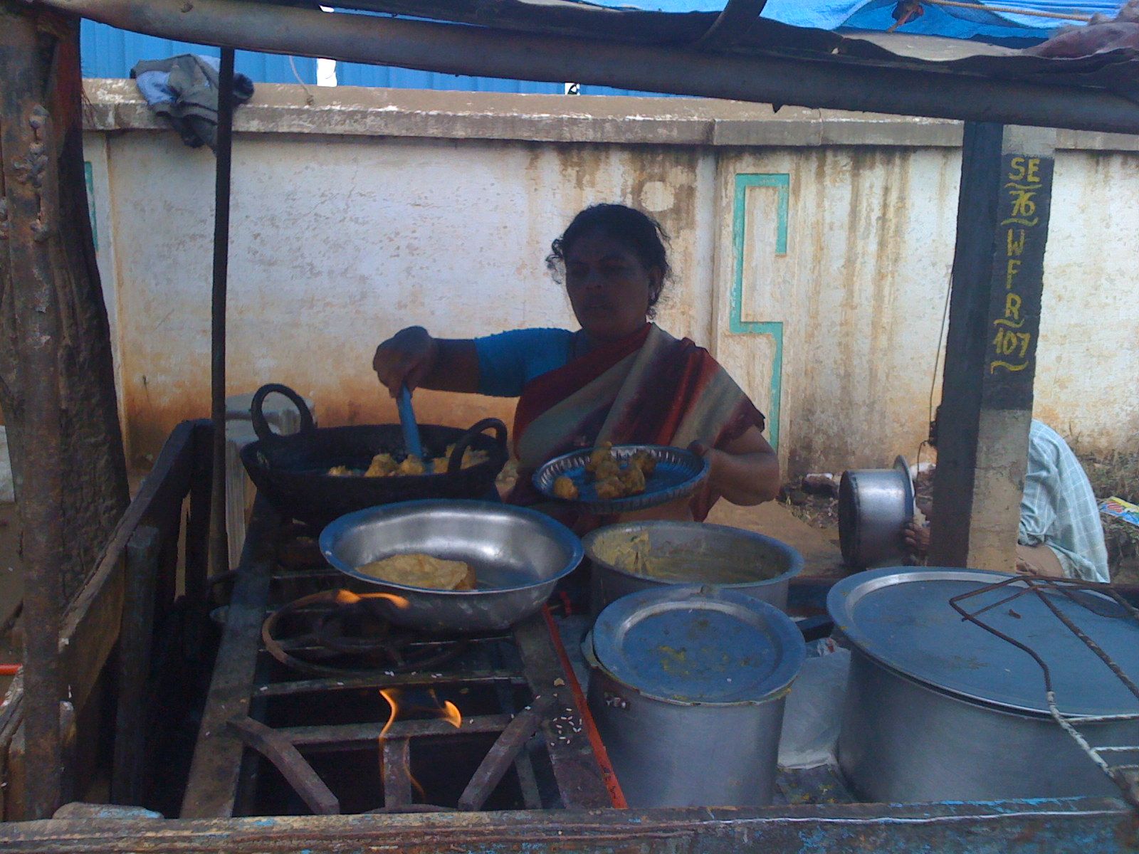 a woman making food in a big pot on the grill
