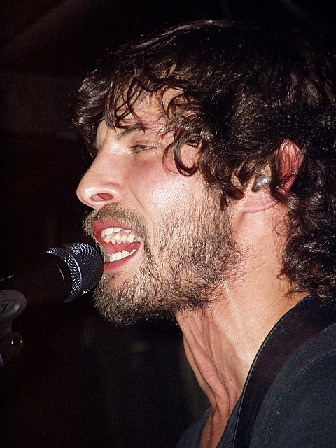 a man with a microphone and long hair