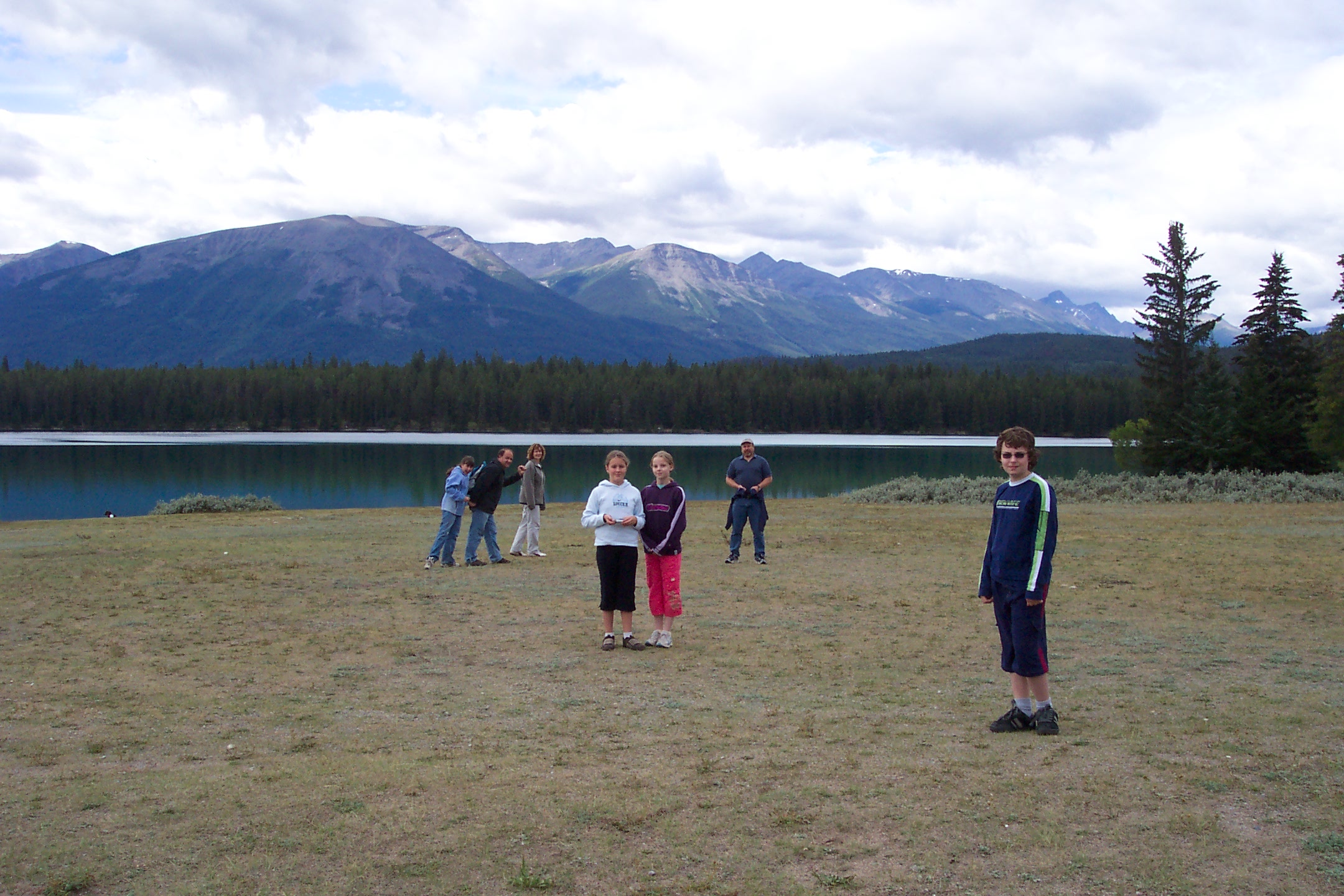 the s are playing frisbee by the lake in the mountains