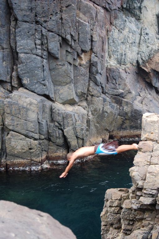 a man falling off a cliff into some water