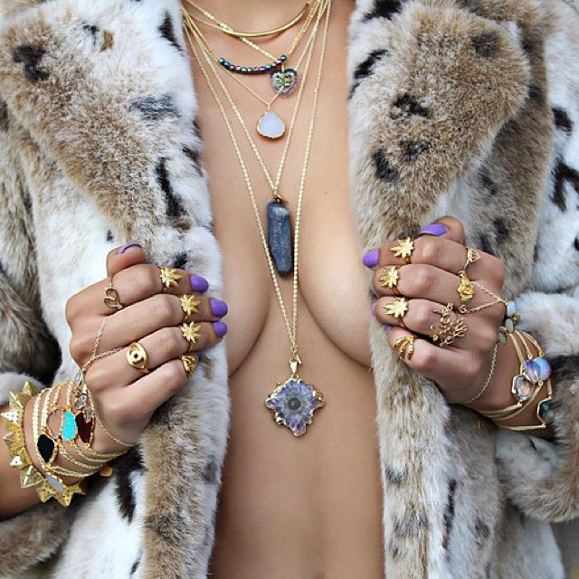 the woman is wearing multiple jewelry pieces including rings and jewels