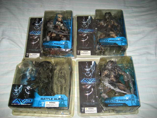 six different action figures in plastic packaging on a bed