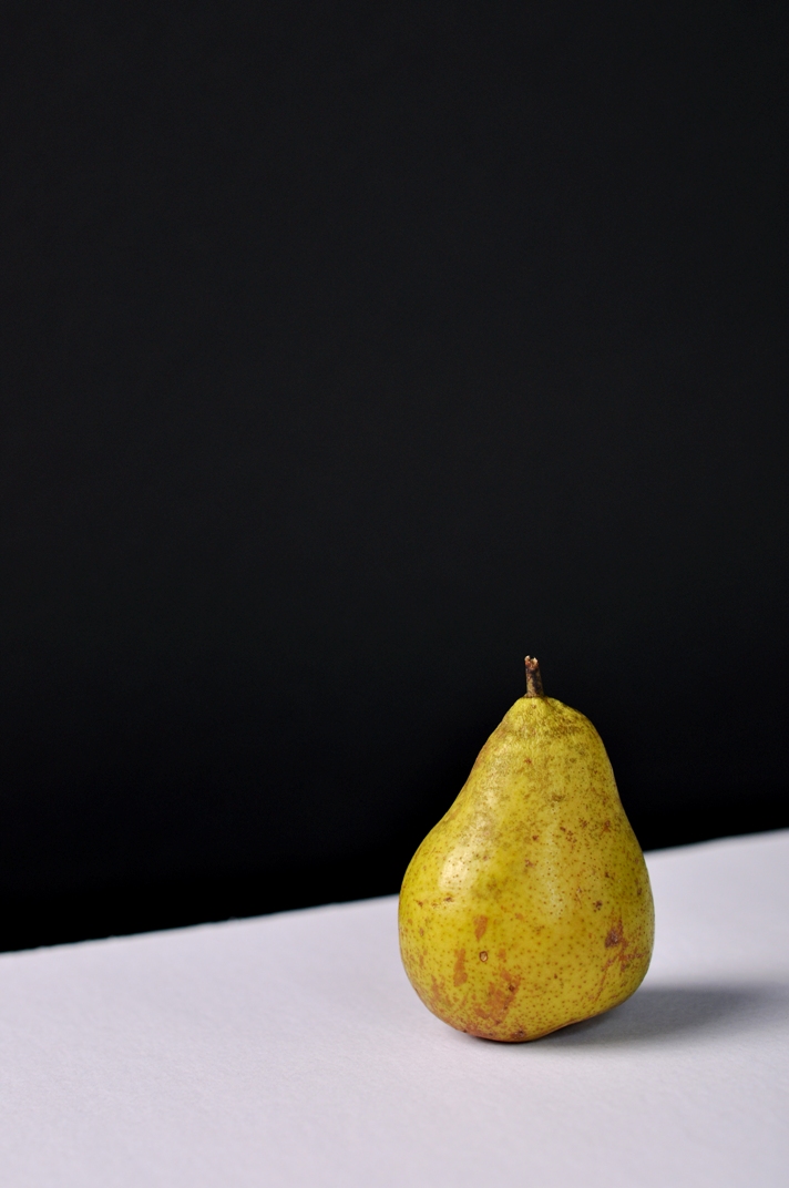 a half eaten ripe pear on a white table