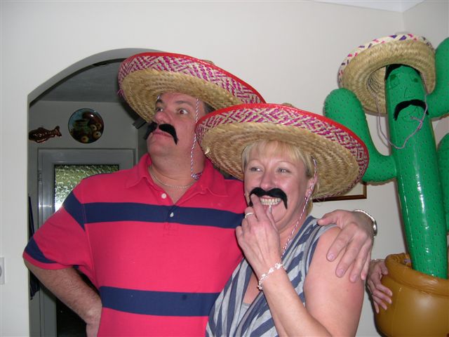 a couple posing together for a po wearing sombreros