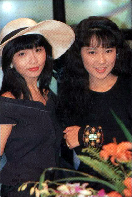 two woman standing next to each other wearing hats