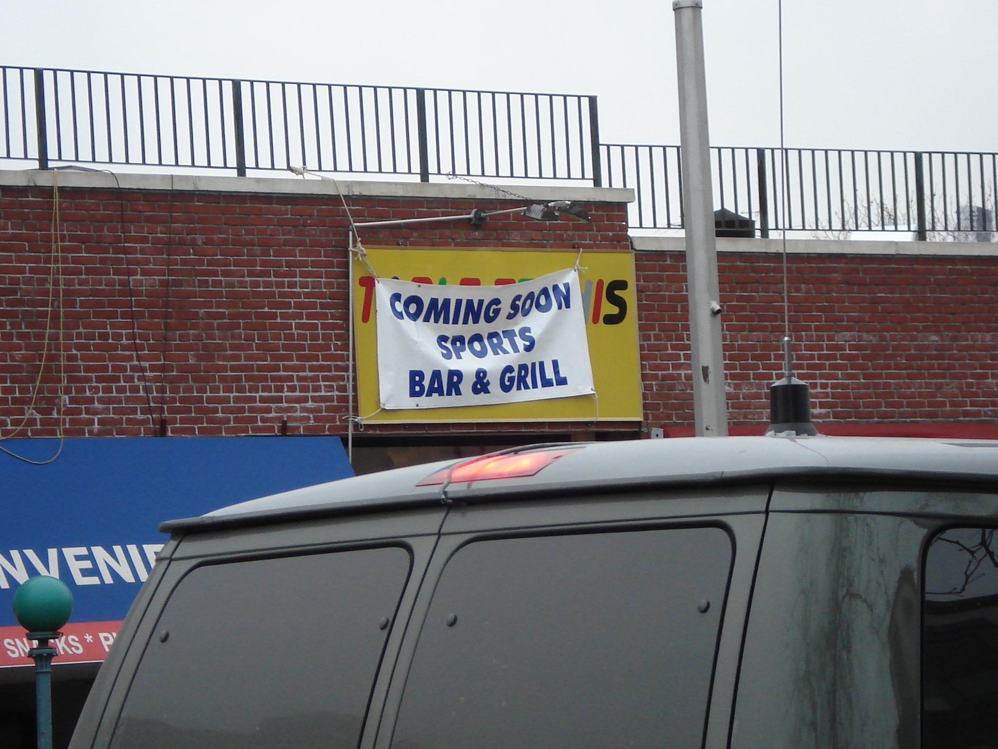 a sign advertising a bar and grill is on the side of the building