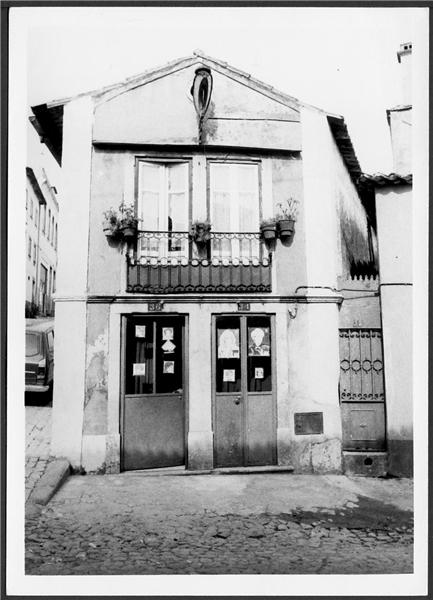 an old building has two doorways and three balconies