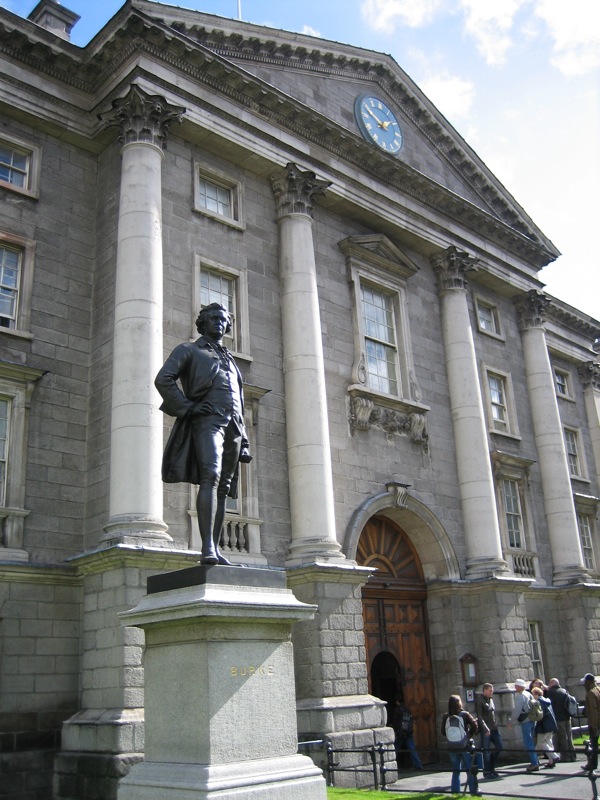 a statue in front of a stone building and flagstone pillars