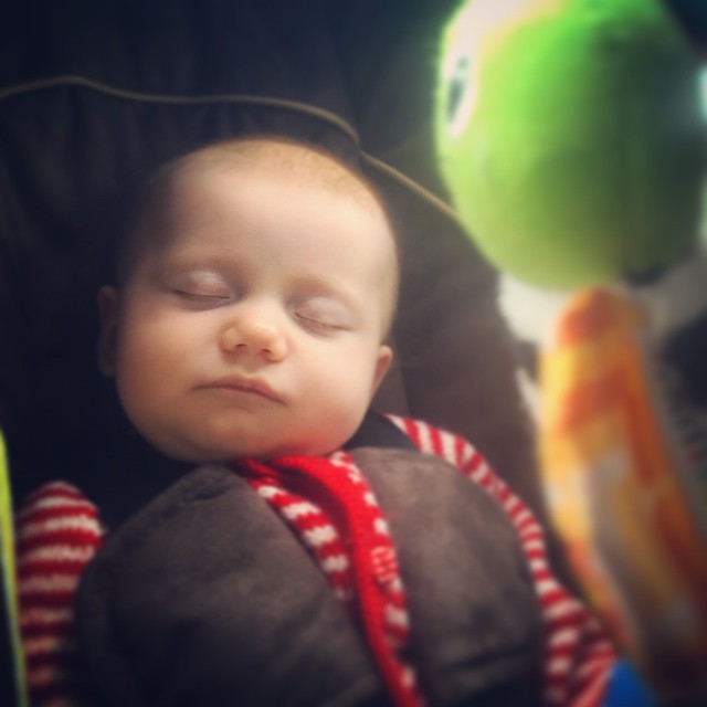 a baby in a car seat with its eyes closed
