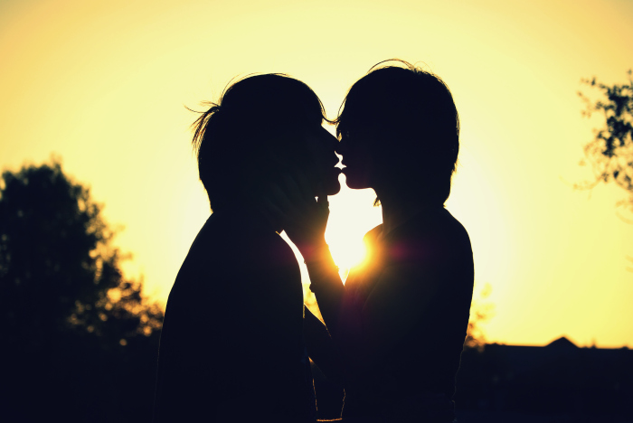 two people face to face, with the sun just behind them