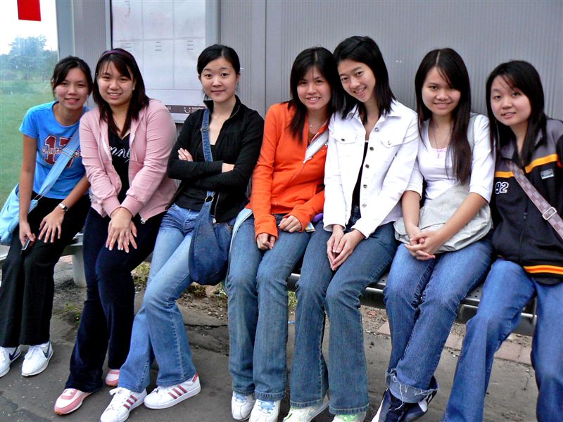 a group of asian girls posing on a bench