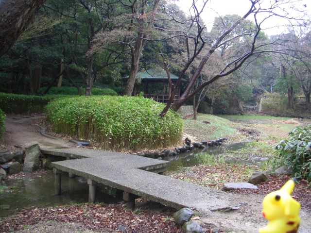 a small bridge over a stream surrounded by grass and rocks