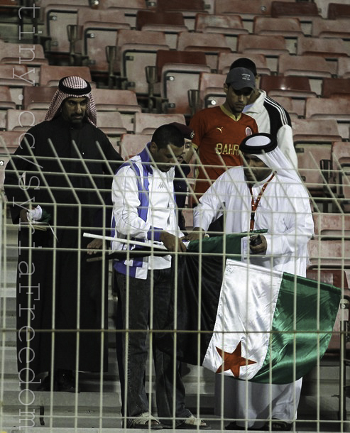 a group of men holding a small flag at a soccer game