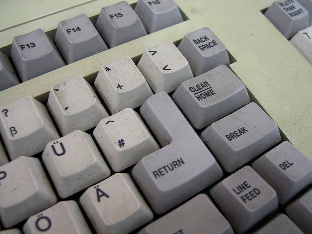 a close up of a gray keyboard and writing on the keys