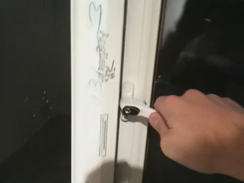 hand holding white refrigerator handle while writing on it