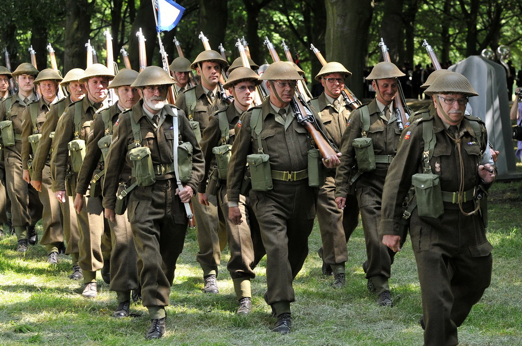 a bunch of men in army uniforms marching in a line