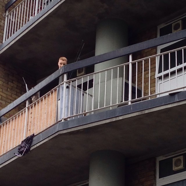 a man stands on his balcony of an apartment building