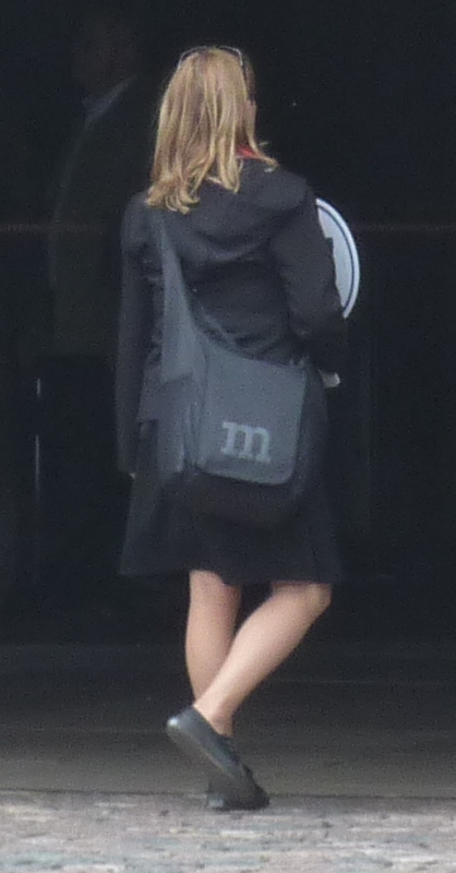 a woman in black jacket and boots walking