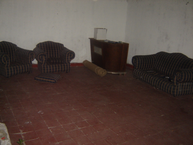 an empty living room with chairs, tv and rugs