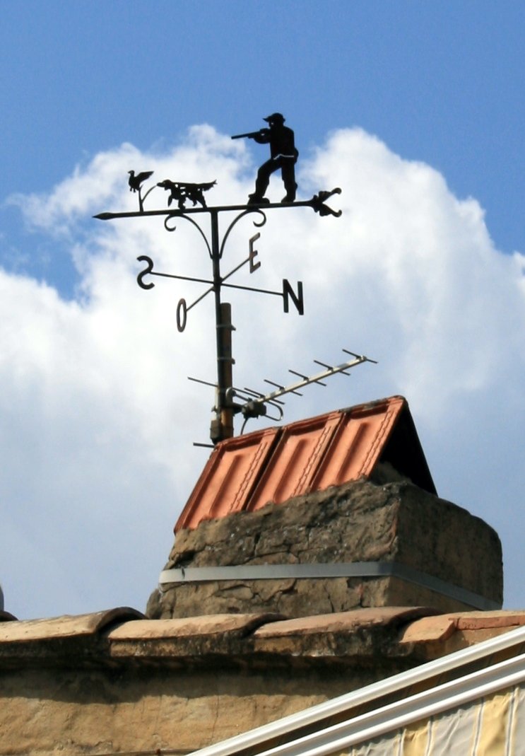 a weather vane sits on top of a stone wall