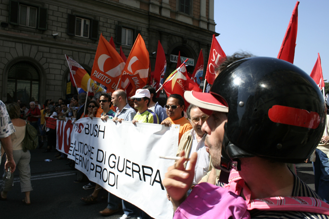 many people holding flags and helmets are on the street