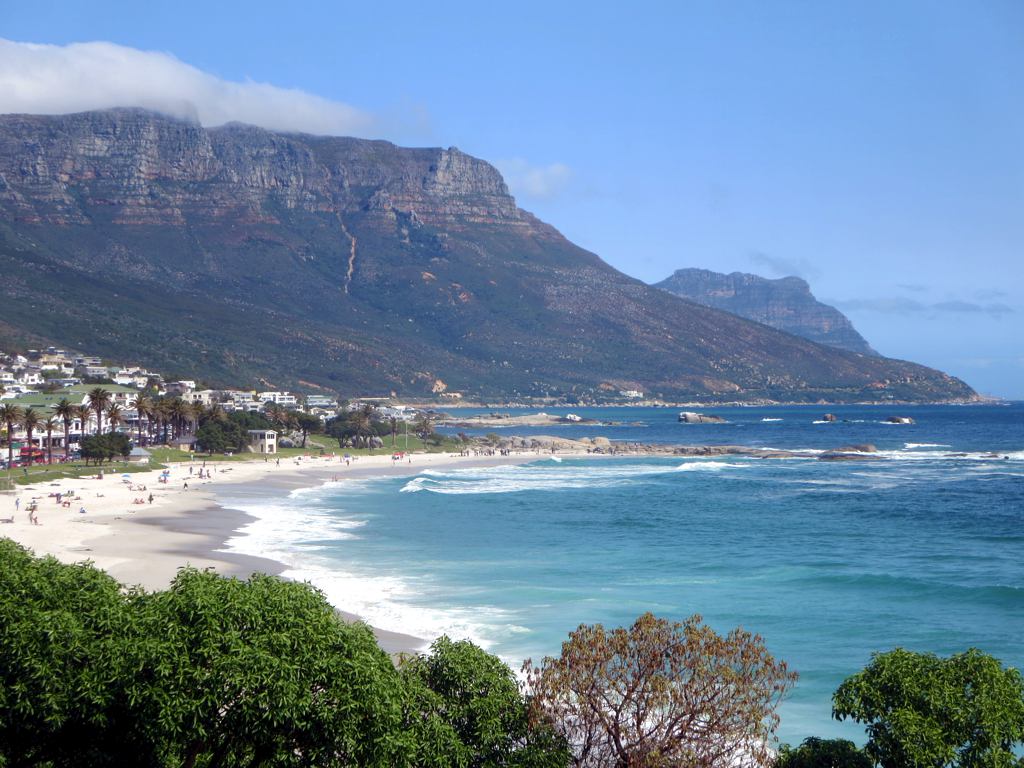 people on a beach with many mountains in the distance