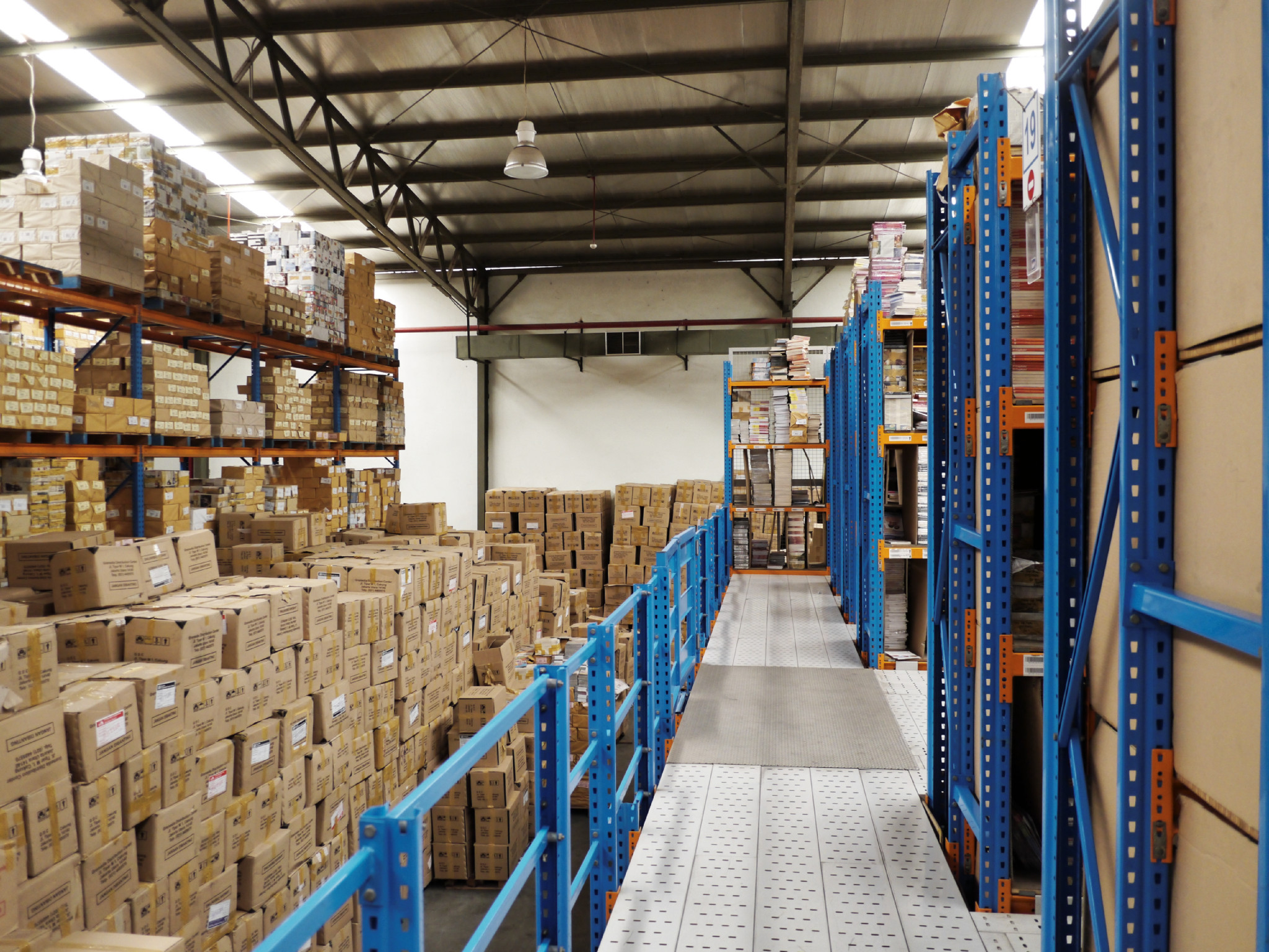 boxes stacked up in the aisle of an industrial warehouse