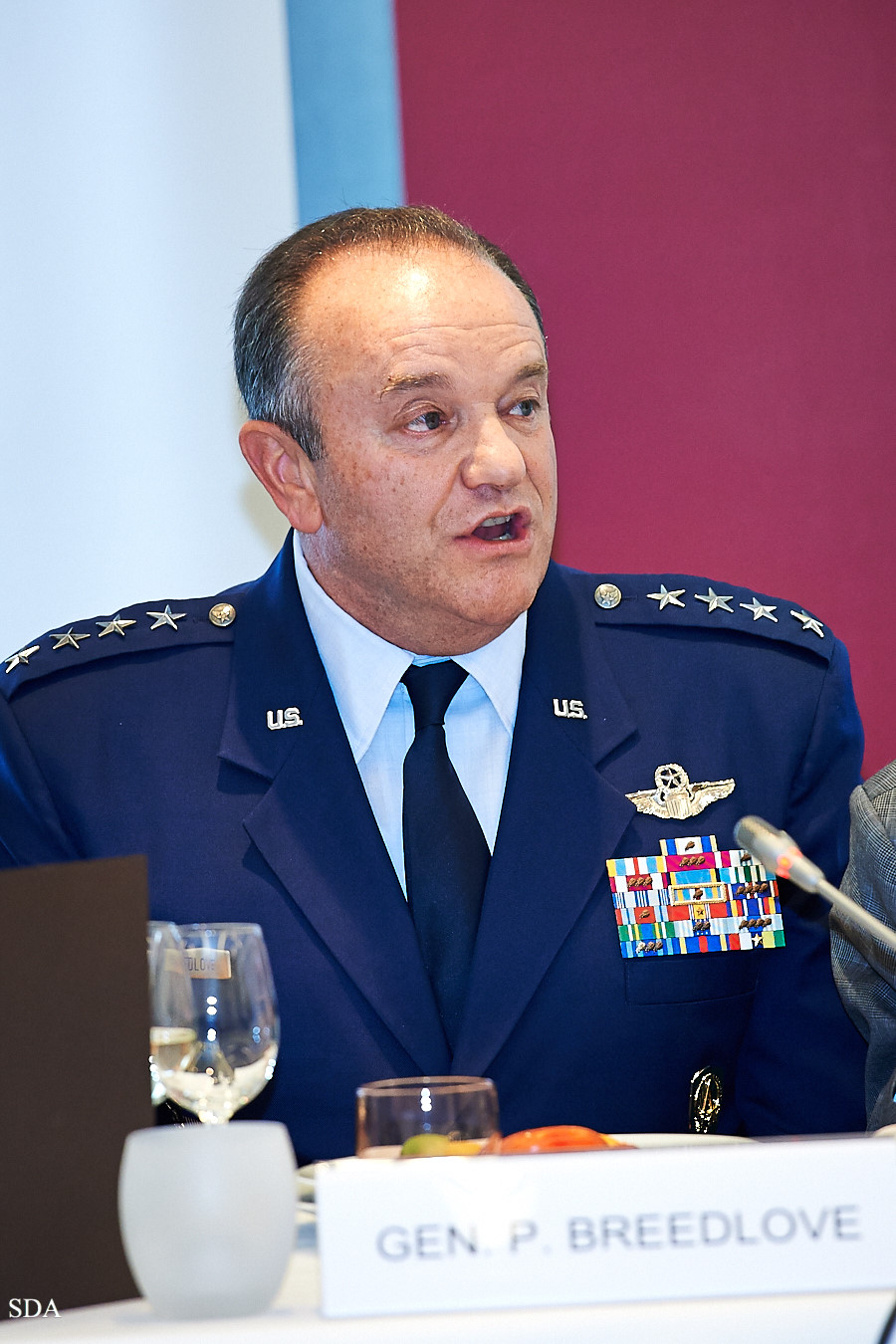 a man wearing military attire speaking into a microphone