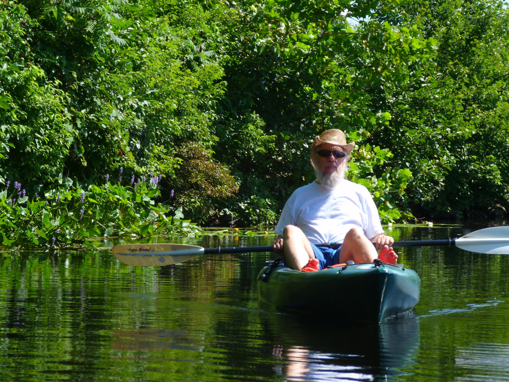 a man sitting in a canoe on a body of water