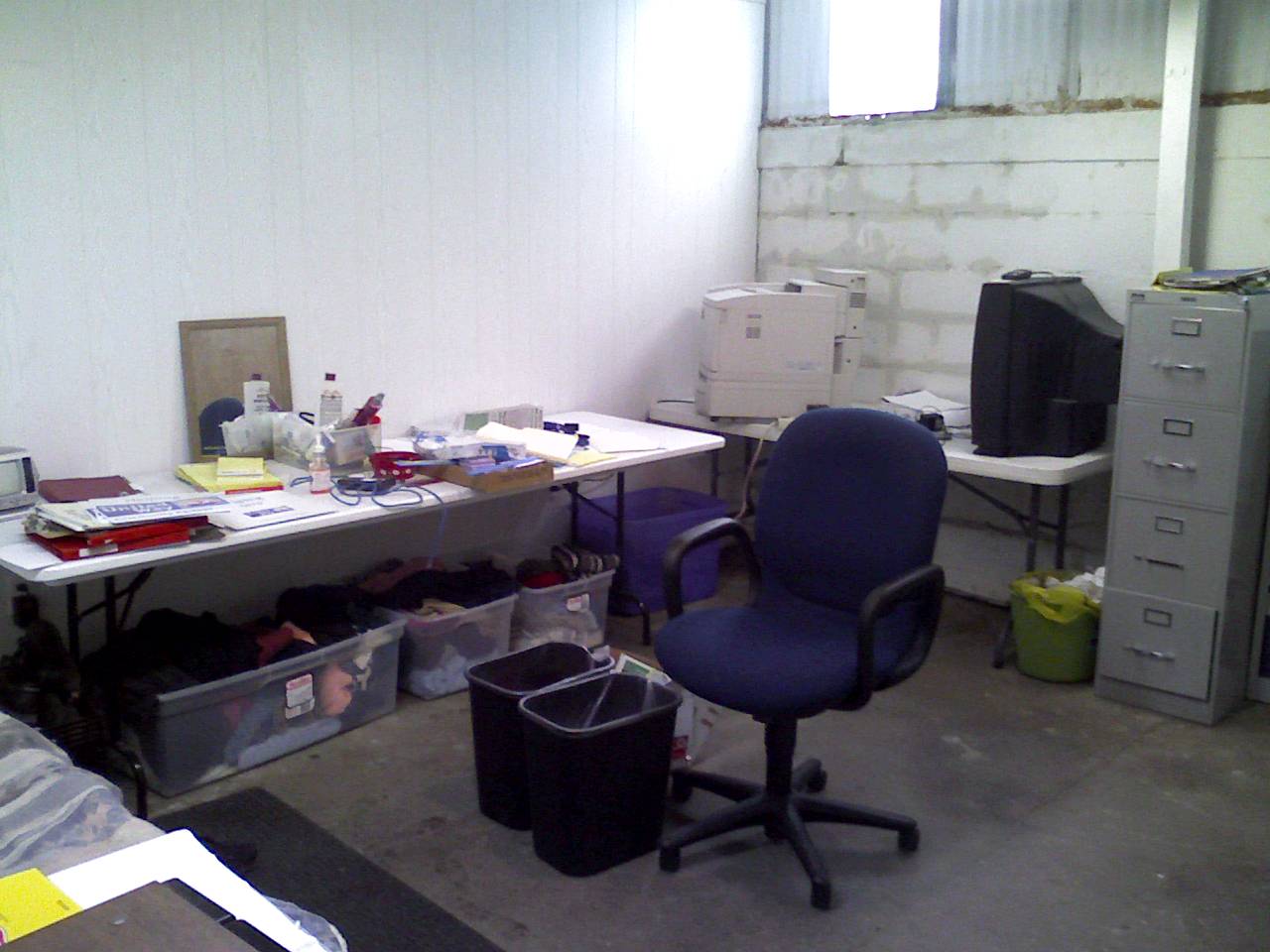 an office room filled with a computer desk and several drawers