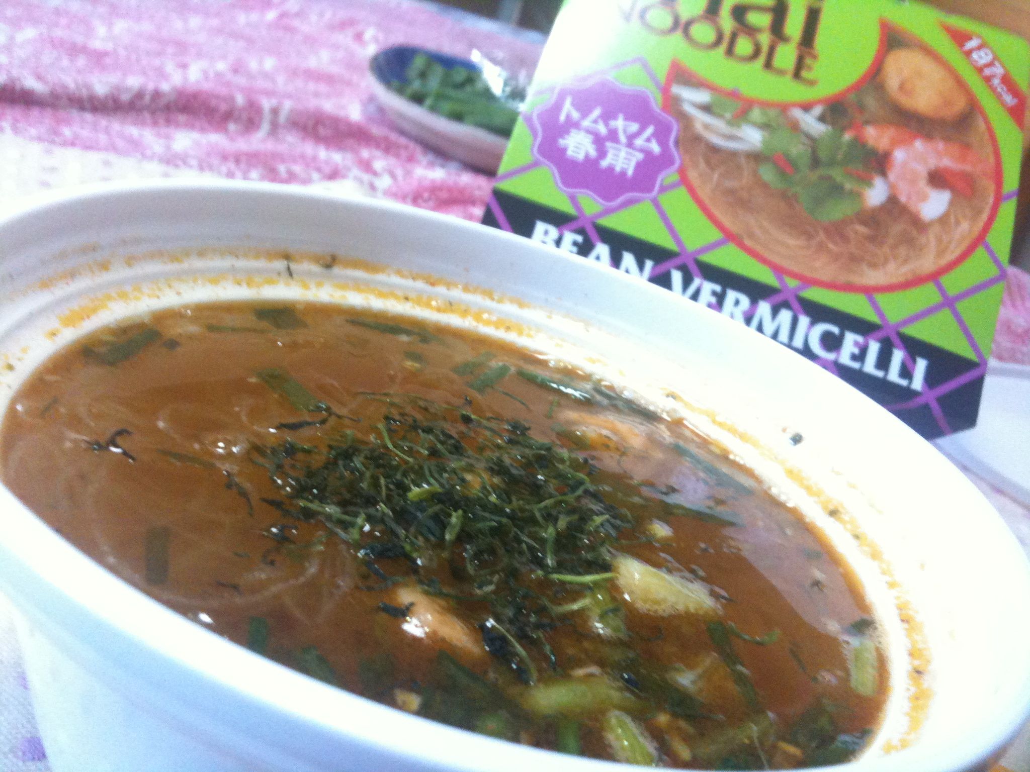 a bowl of soup sits in front of a cereal box