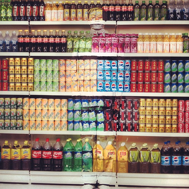 a bunch of sodas and lemonade sitting on shelves