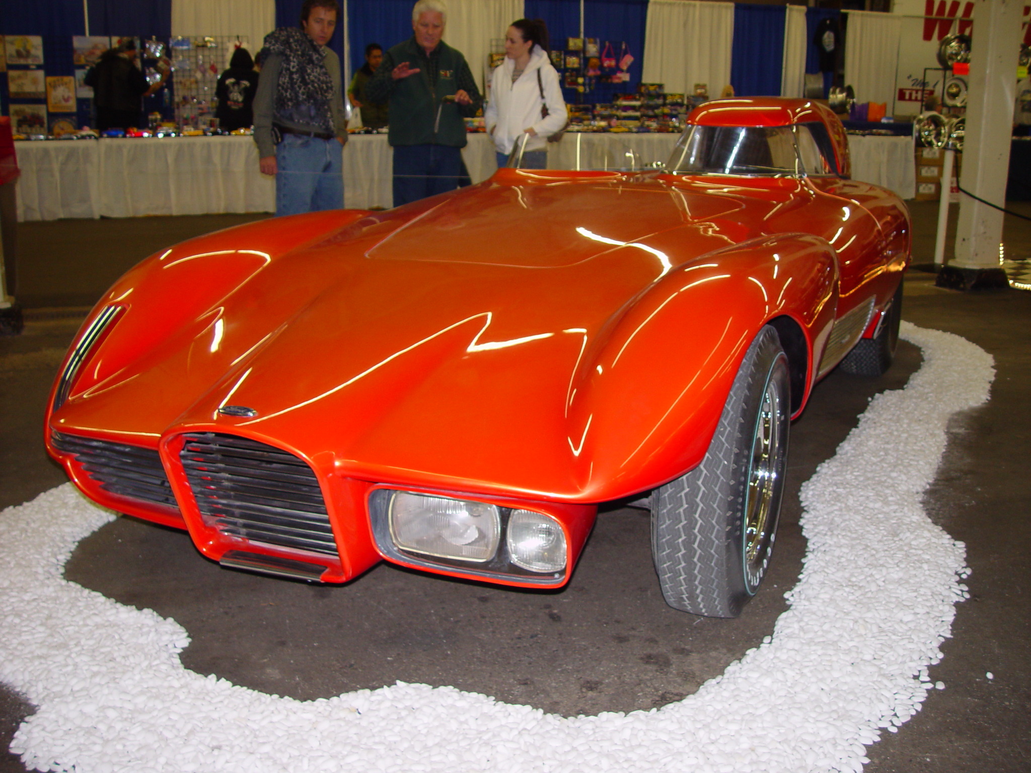 an old model orange sport car sits on display