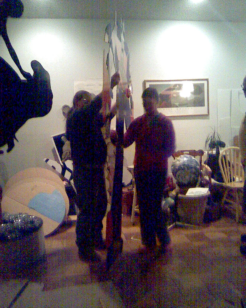 two men are standing near a room full of guitars