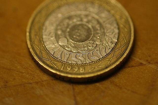 a picture of a one pound coin on a wooden table