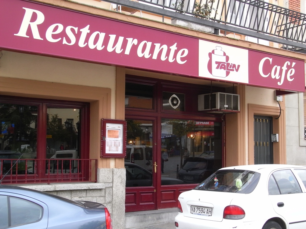 a pink cafe with many signs hanging outside