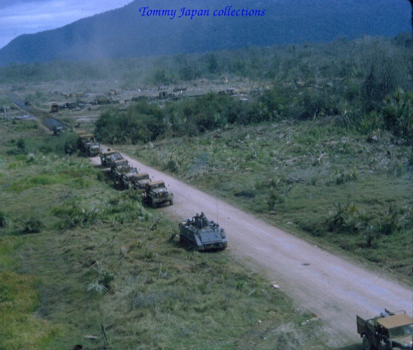 several army vehicles parked along a dirt road
