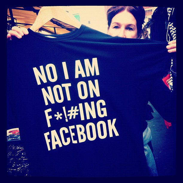 a woman holding a t - shirt up to her face