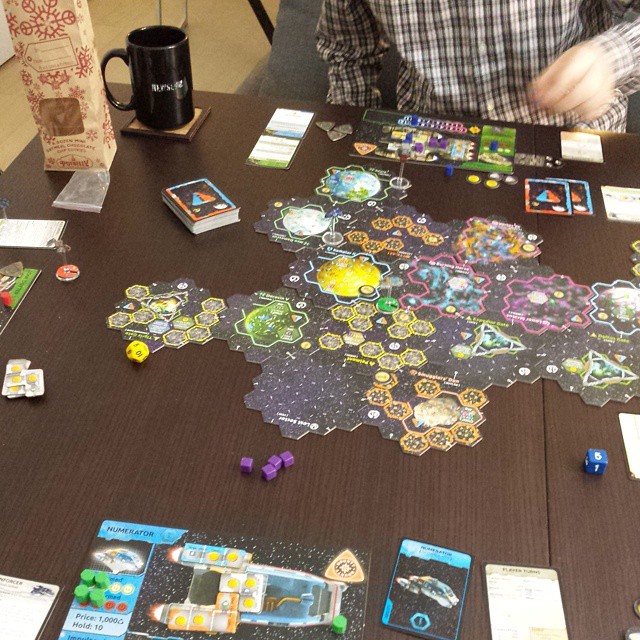 a table is covered in board game pieces and items