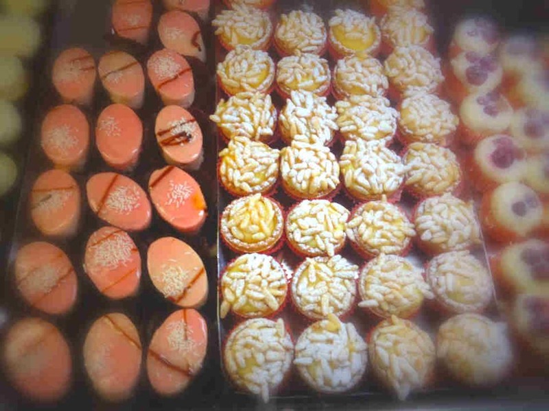 orange and white macaroni cookies in a display case