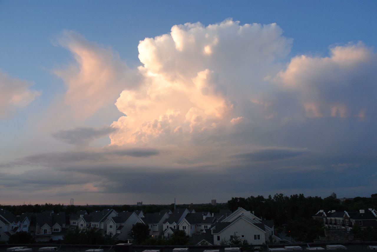 a large cloud hovers over the top of some buildings