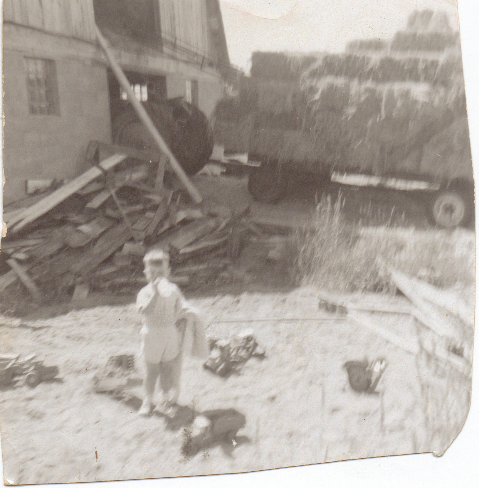 a small boy standing in front of a pile of items