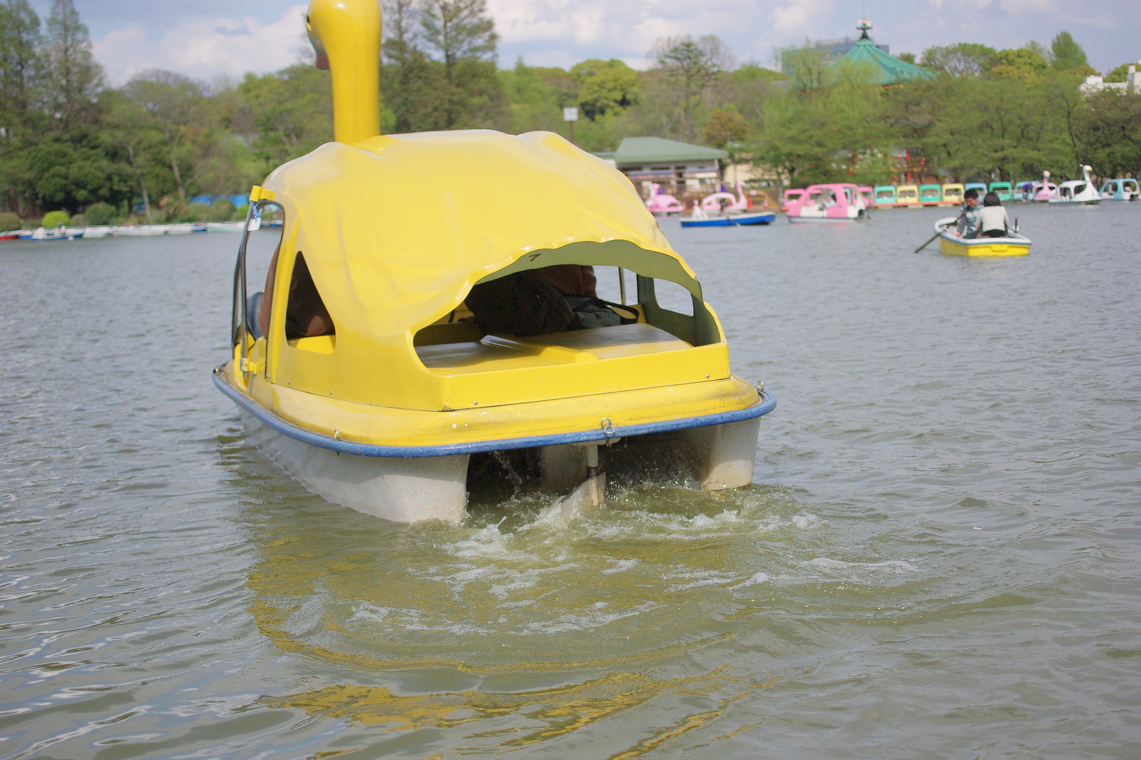 a water craft in a lake with people in the background