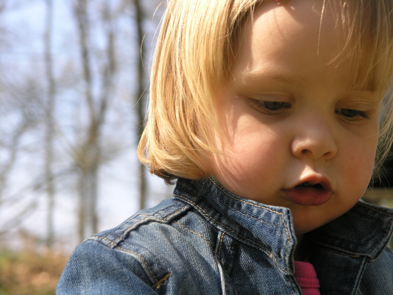 a young child in jean jacket making a funny face