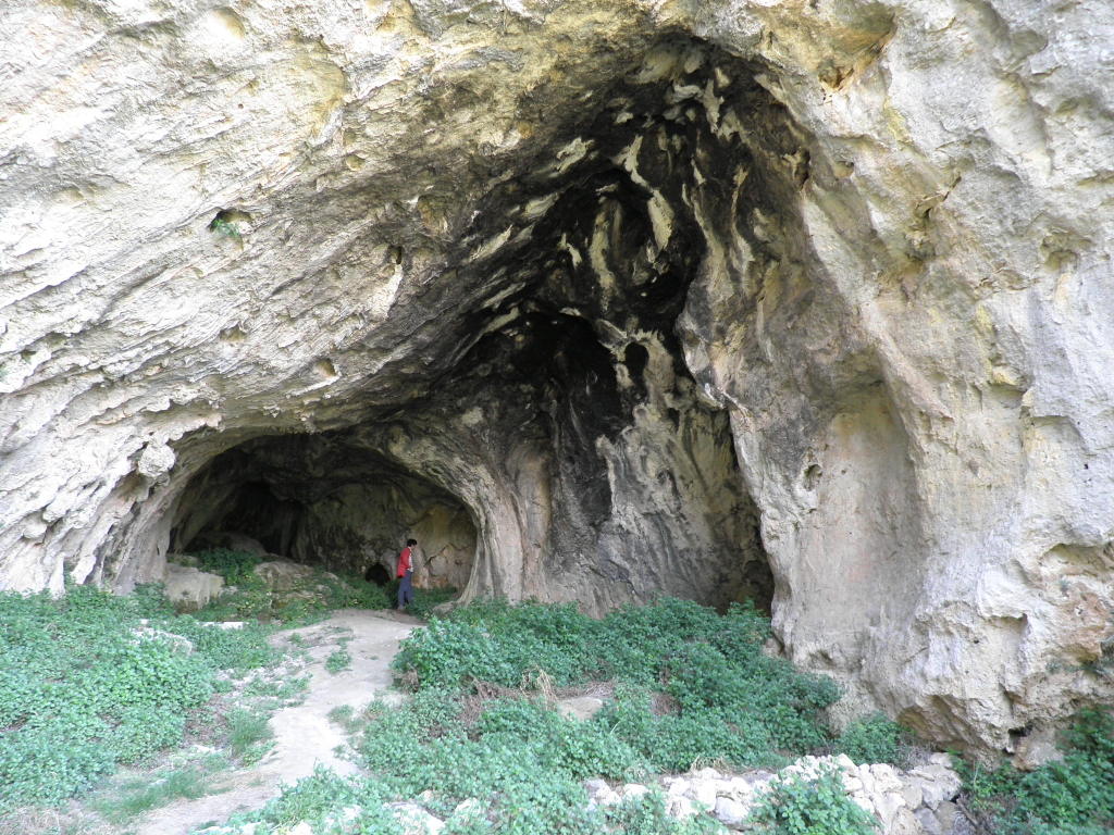 people are walking out of an area with stone formations