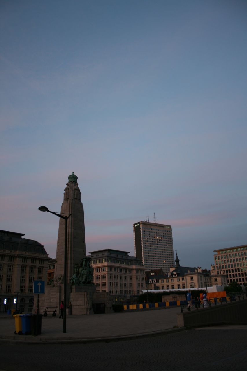 tall clock tower with a street light at dusk