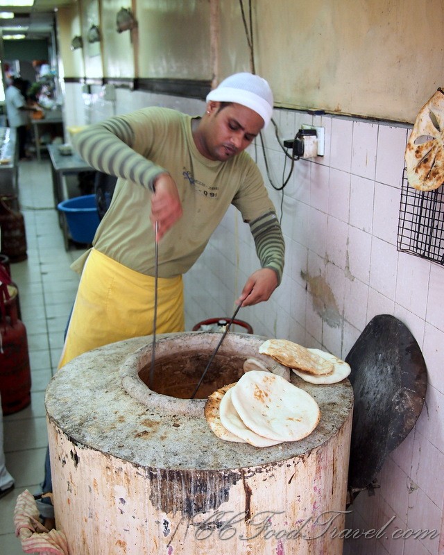 a man cooking in a pot with a large spatula