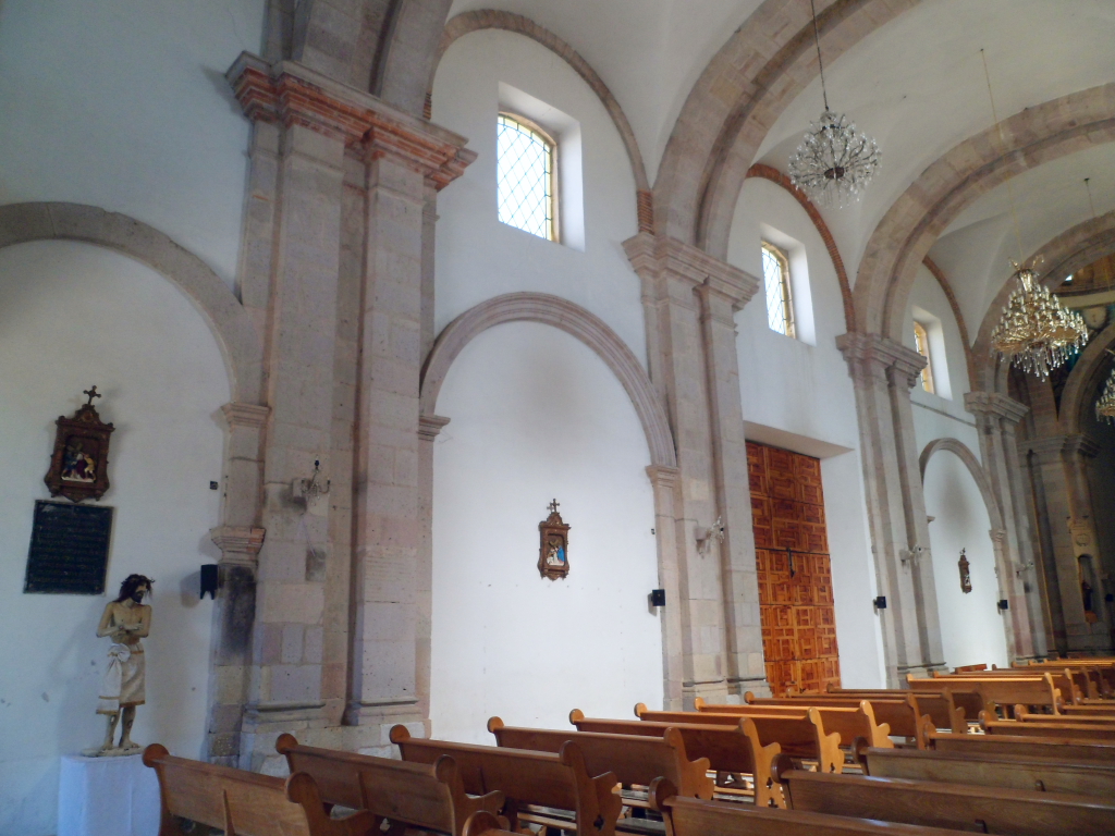 an ornate church building with two large arches and wooden pews