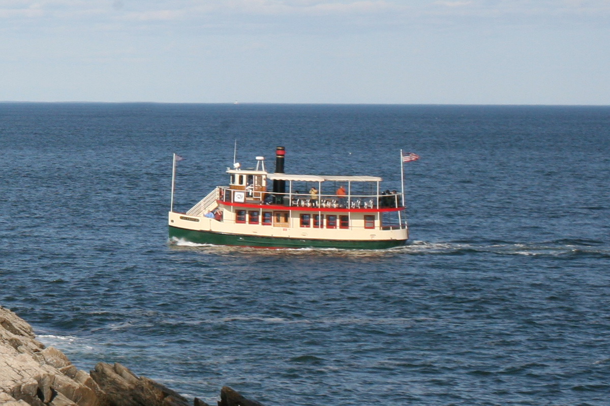 a red and white boat traveling on top of the ocean