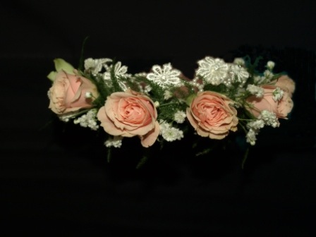 four pink flowers laying on a head piece